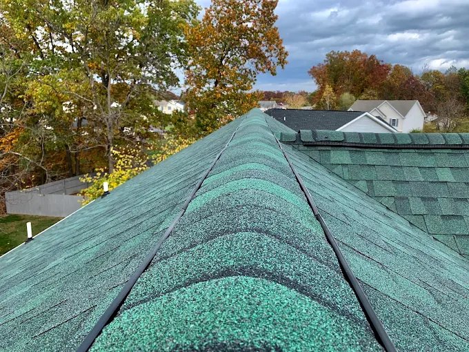 Green architectural shingle roof with ridge and hip caps